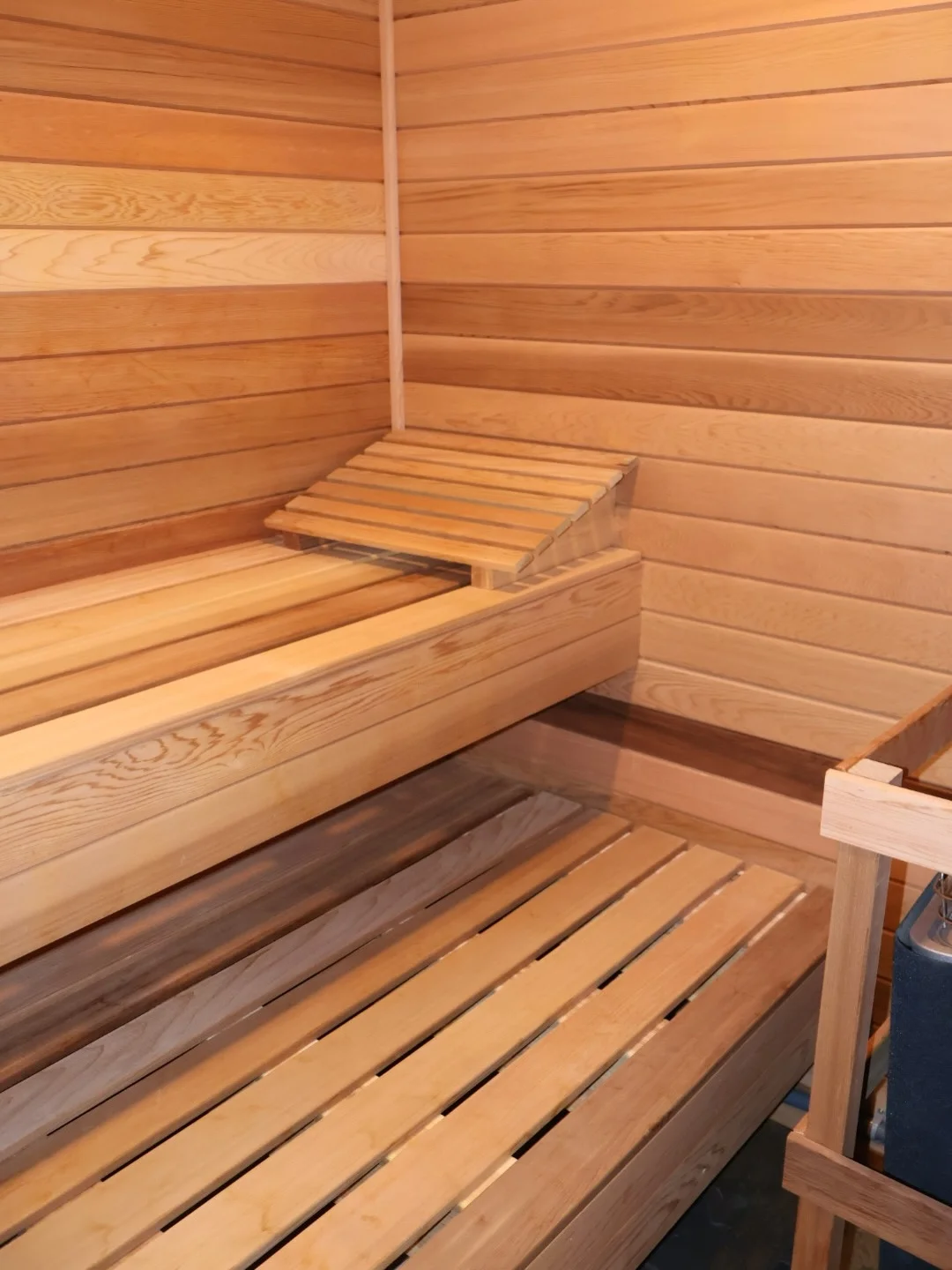 Interior sauna with cedar paneling walls and multi-level wooden bench seating